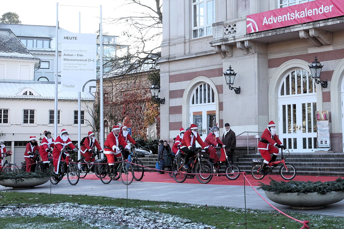Radelnde Weihnachtsmänner und -frauen vor dem Theater in Baden-Baden