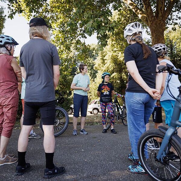 Die ADFC-Radspaß-Trainerin hilft der Teilnehmenden bei der Einstellung des Helmes