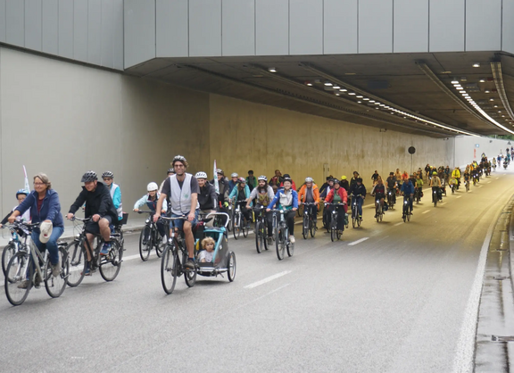 Eine Fahrraddemo fährt auf der Südtangente durch einen kurzen Tunnel.